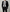 Man wearing a black suit with a white shirt and black tie on a grey background