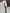 Light grey suit with white shirt, stripe tie and black belt on a dark background