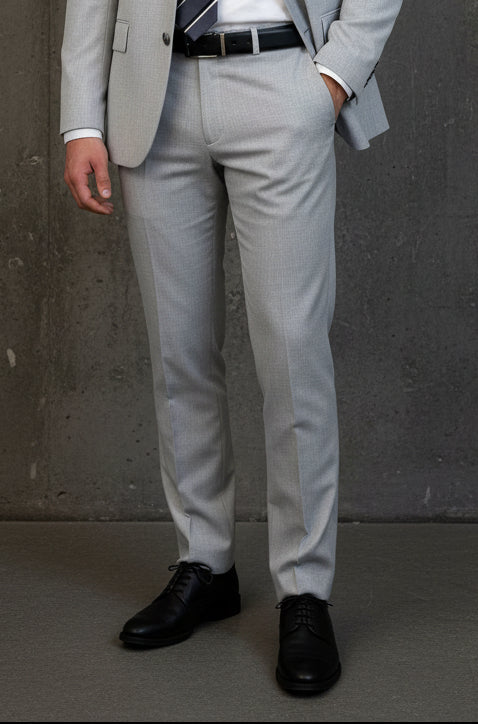 Light grey smart pants with a black belt on a dark background