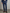 Man wearing a dark blue smart pants with a brown belt and shoes on a plain background