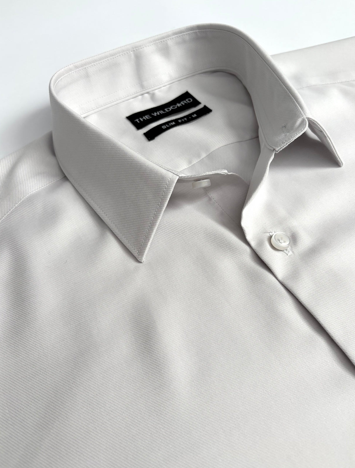 Light silver smart shirt with collar and label on a light background